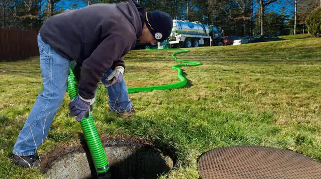 Service technician performing residential septic pumping and drainage maintenance in Bloomington, IN